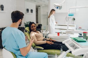 dentist and dental assistant reassuring patient and helping her relax at the dentist